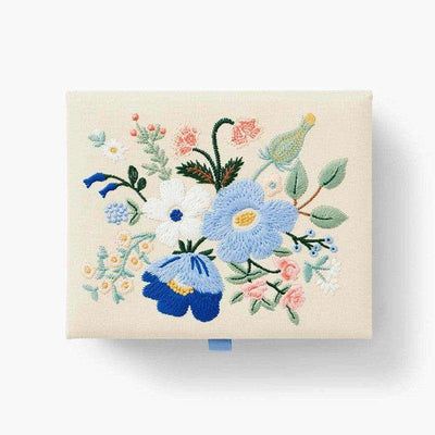 Caja Mediana Strawberry Fields bordada con motivos florales sobre tela cruda, con cierre magnético y cinta azul celeste.